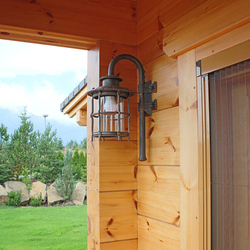 A wrought iron wall lighting in a mountain cottage patio - luxury outdoor lamp A wrought iron wall lighting in a mountain cottage patio - luxury outdoor lamp