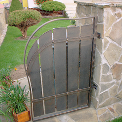 A wrought iron gate for a rubbish bin