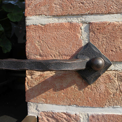 Jednoduchý kovaný držiak kvetináčov na okne rodinného domu - detail Jednoduchý kovaný držiak kvetináčov na okne rodinného domu - detail