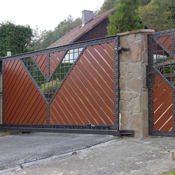 A wrought iron gate - wood - metal, harmony of materials 