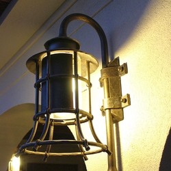 A wrought iron lamp with a shade