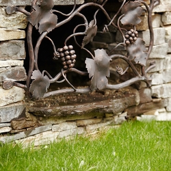 Hand forged grille with a vine theme on a wine cellar