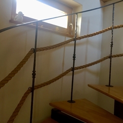 Kované zábradlie s lanom na interiérovom točitom schodisku Kované zábradlie s lanom na interiérovom točitom schodisku